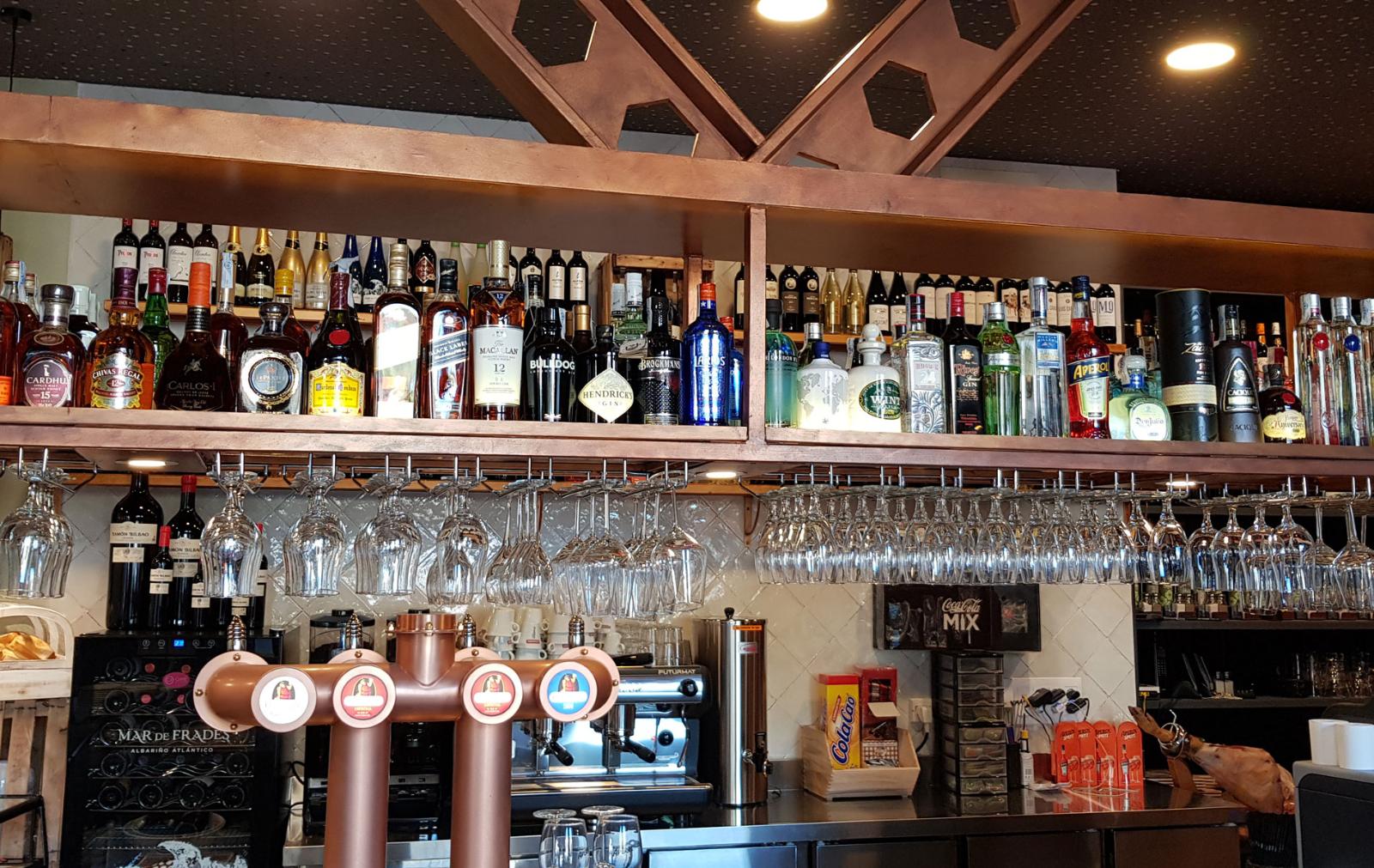 Barra con botellas y grifos de cerveza en La Malvaloca, Sevilla